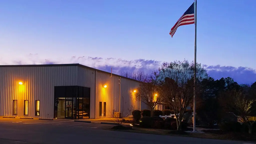 The Lions Industries plant at 4126 Berkeley Ave at dusk, flag flying